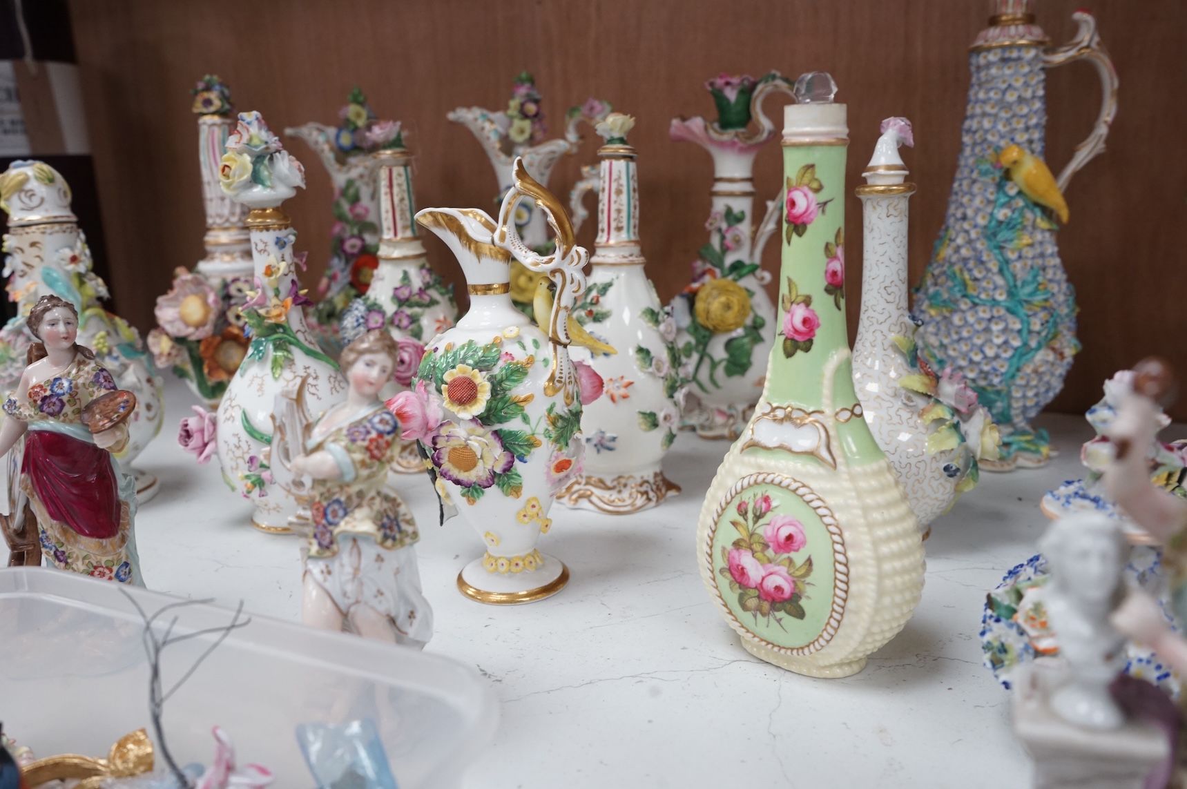 A group of English porcelain flower encrusted scent bottles and yours, Coalport, Minton etc., c.1830-50 together with Continental porcelain figures a wall pocket etc, largest 26cm high